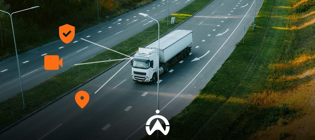 A white truck on a multi-lane road, with icons indicating tracking, video, and location features for fleet management.