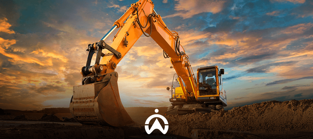 A yellow excavator stands in a construction site under a dramatic sunset sky, with its bucket poised over a pile of earth.