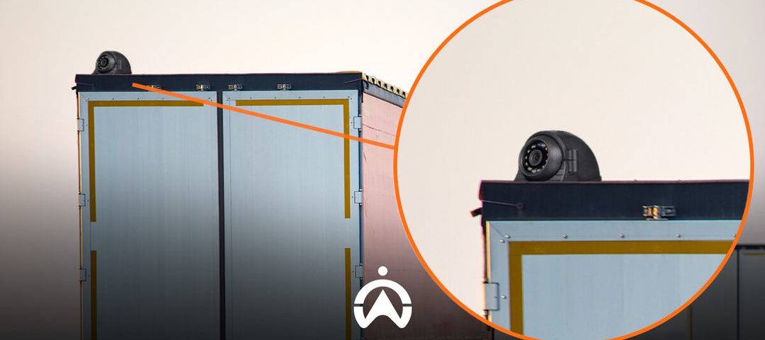 A close-up of the top of a truck trailer featuring a radar device, with the trailer's doors prominently displayed.