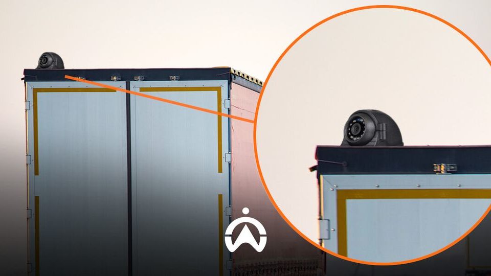 A close-up of the top of a truck trailer featuring a radar device, with the trailer's doors prominently displayed.