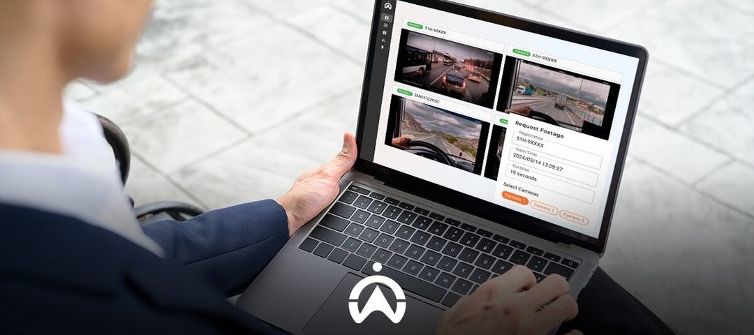 A person interacts with a laptop displaying multiple camera feeds and a request form for video footage.