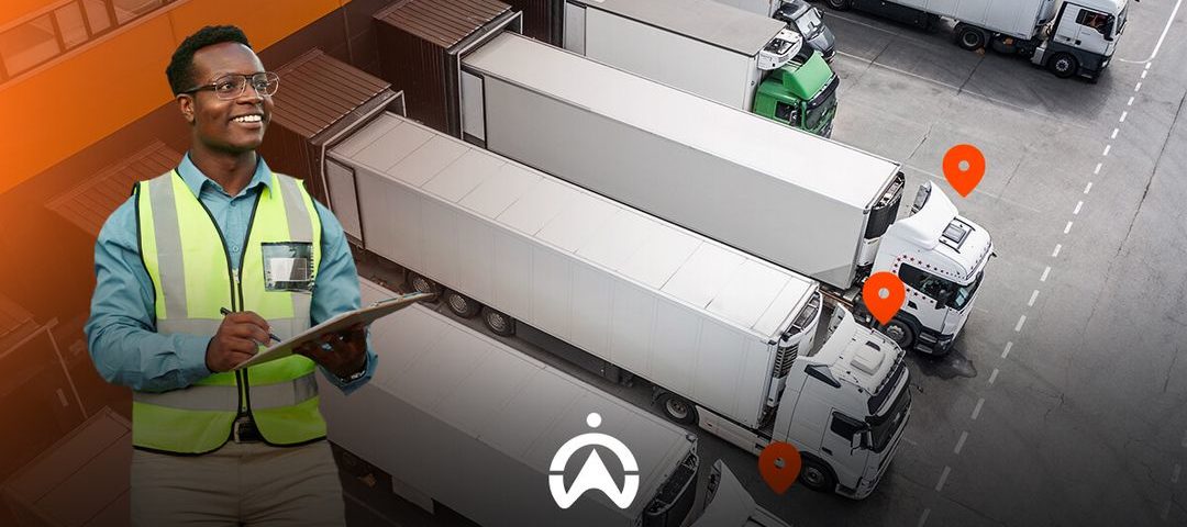 A logistics worker in a reflective vest stands near a fleet of trucks marked with orange location pins in a loading area.