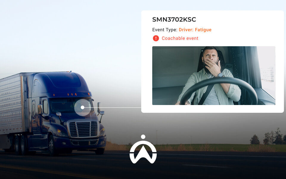A blue semi-truck drives on an open road, with an overlay detailing driver fatigue as a coachable event.