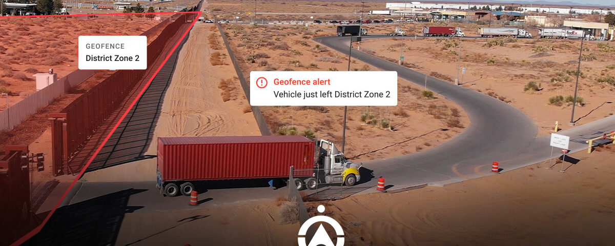 A truck exits a geofenced area labeled "District Zone 2" with an alert indicating its departure in an arid landscape.