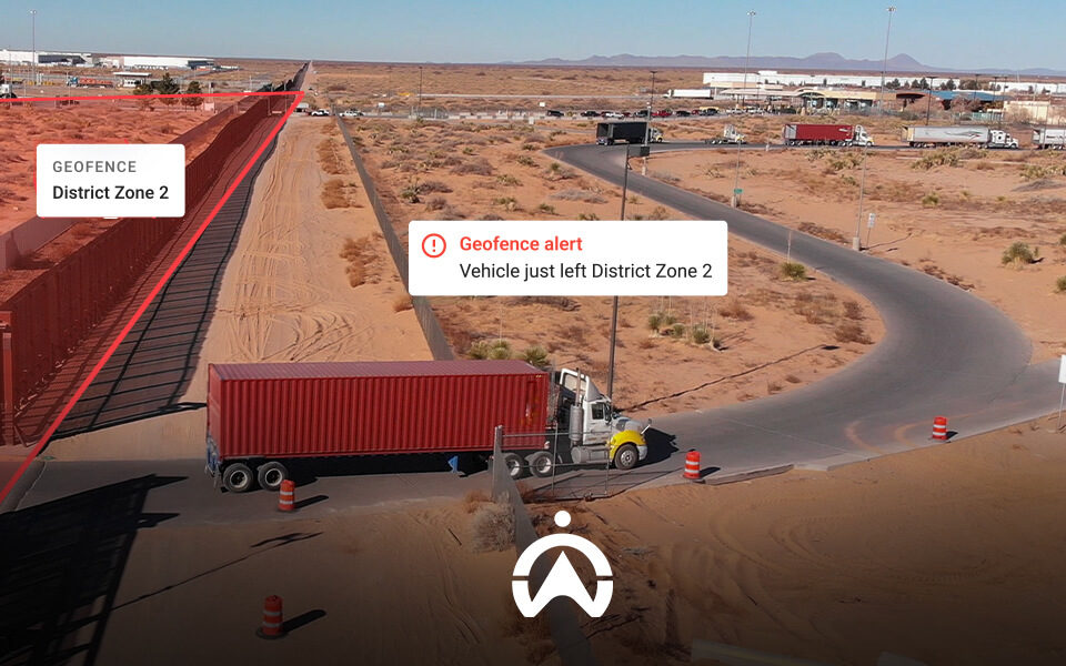 A truck exits a geofenced area labeled "District Zone 2" with an alert indicating its departure in an arid landscape.